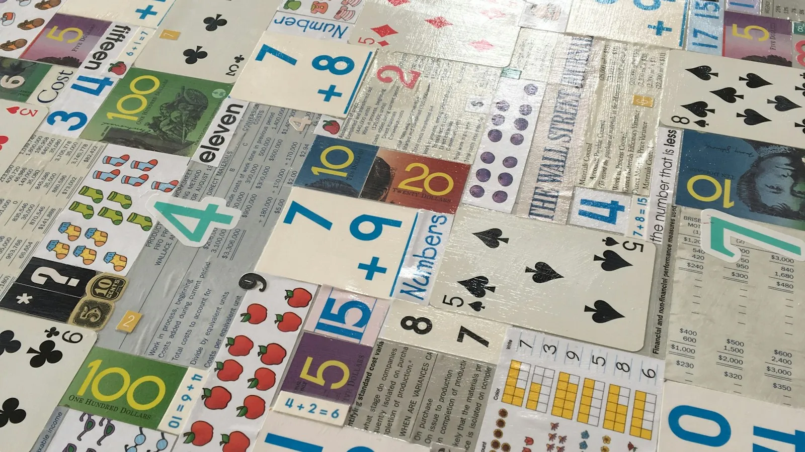 Cartas de baraja y tarjetas educativas con números y sumas extendidas sobre una mesa