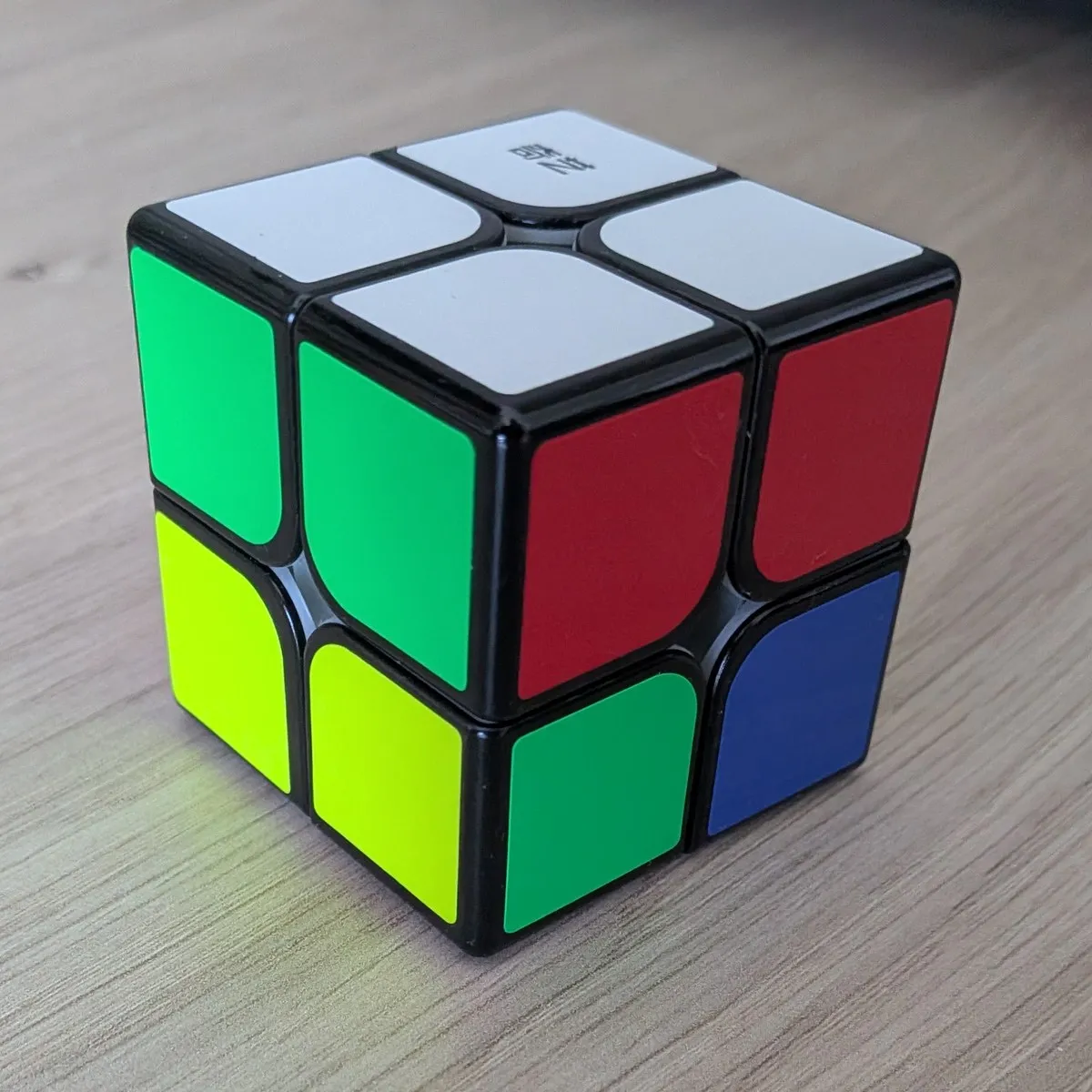 Un cubo de Rubik de 2x2 con la cara blanca completa arriba y la franja superior de los laterales cuadrada, verde con verde y rojo con rojo