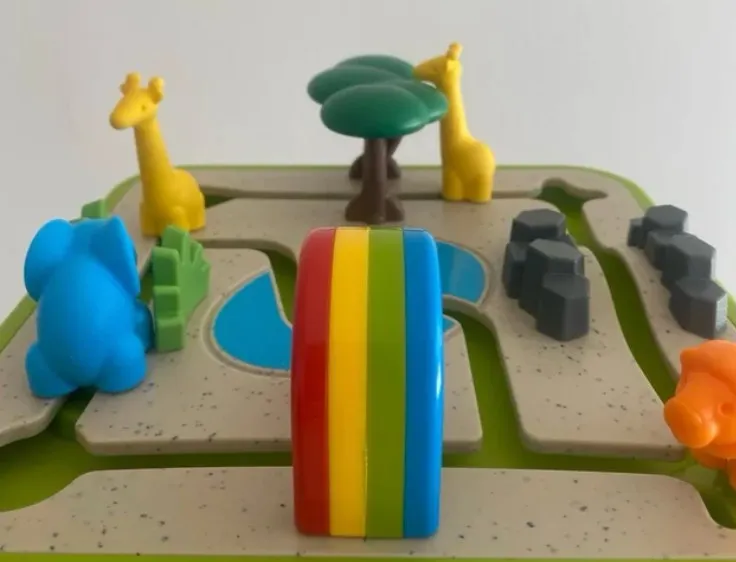 El tablero de Foto Safari montado: dos jirafas y un árbol al fondo, el elefante azul junto al charco, el arcoíris en primer plano y el hipopótamo naranja al borde
