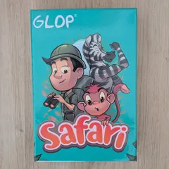 La caja de Glop Safari, con el explorador, la cebra y el mono, vista desde arriba sobre una superficie de madera clara