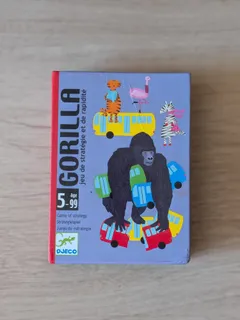 La caja de Gorilla, de Djeco, con el gorila entre autobuses de colores, sobre una mesa de madera