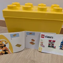 La caja amarilla con forma de ladrillo de LEGO Classic 10698, con los cuadernillos de instrucciones abiertos delante