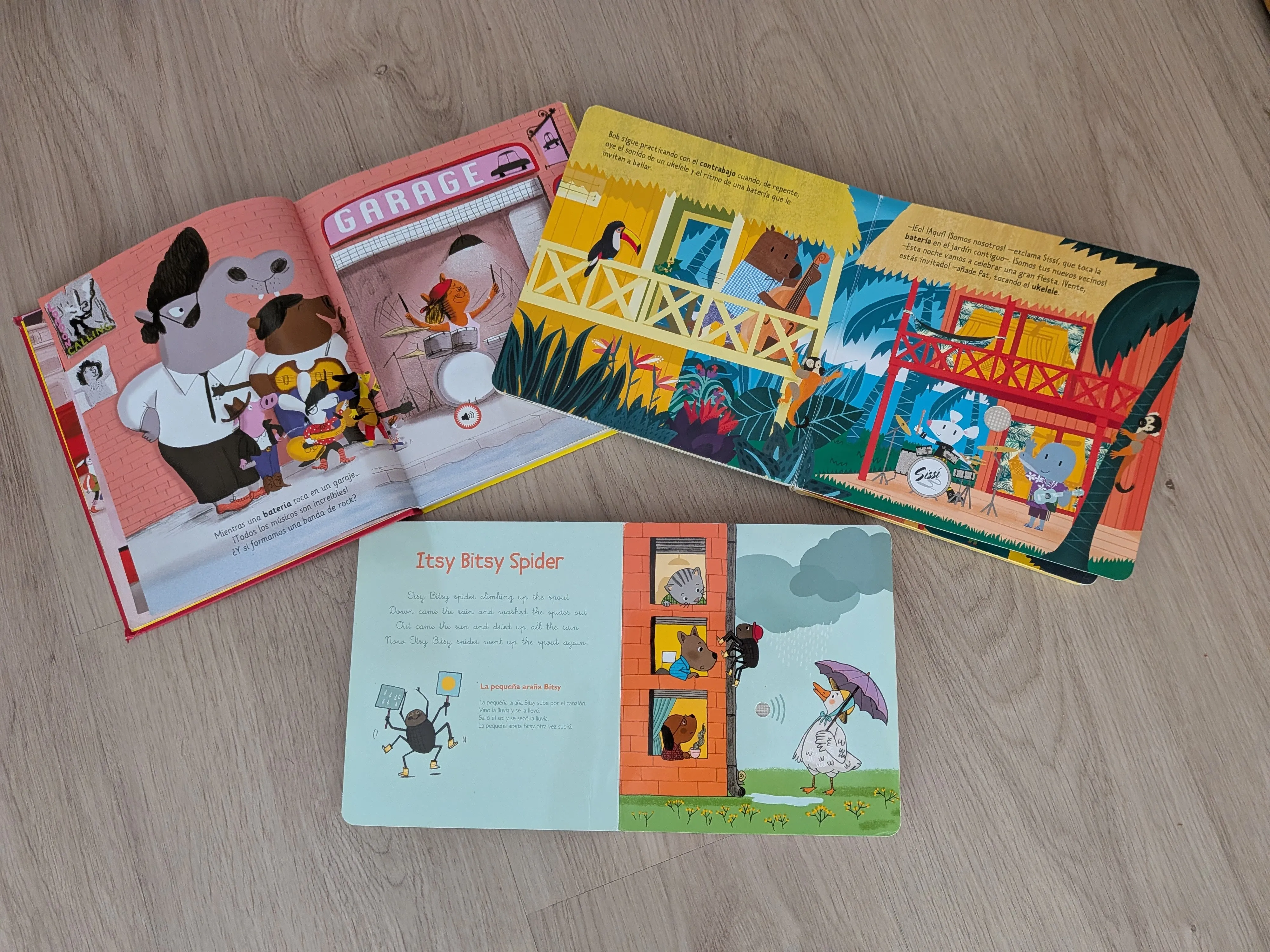Tres libros musicales abiertos sobre el suelo: Paco y el rock, Bob y sus amigos y Mis primeras canciones en inglés por la página de Itsy Bitsy Spider