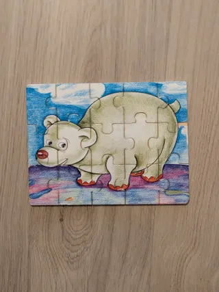 Uno de nuestros puzzles de madera de 12 piezas, montado sobre una mesa: un oso sobre el hielo